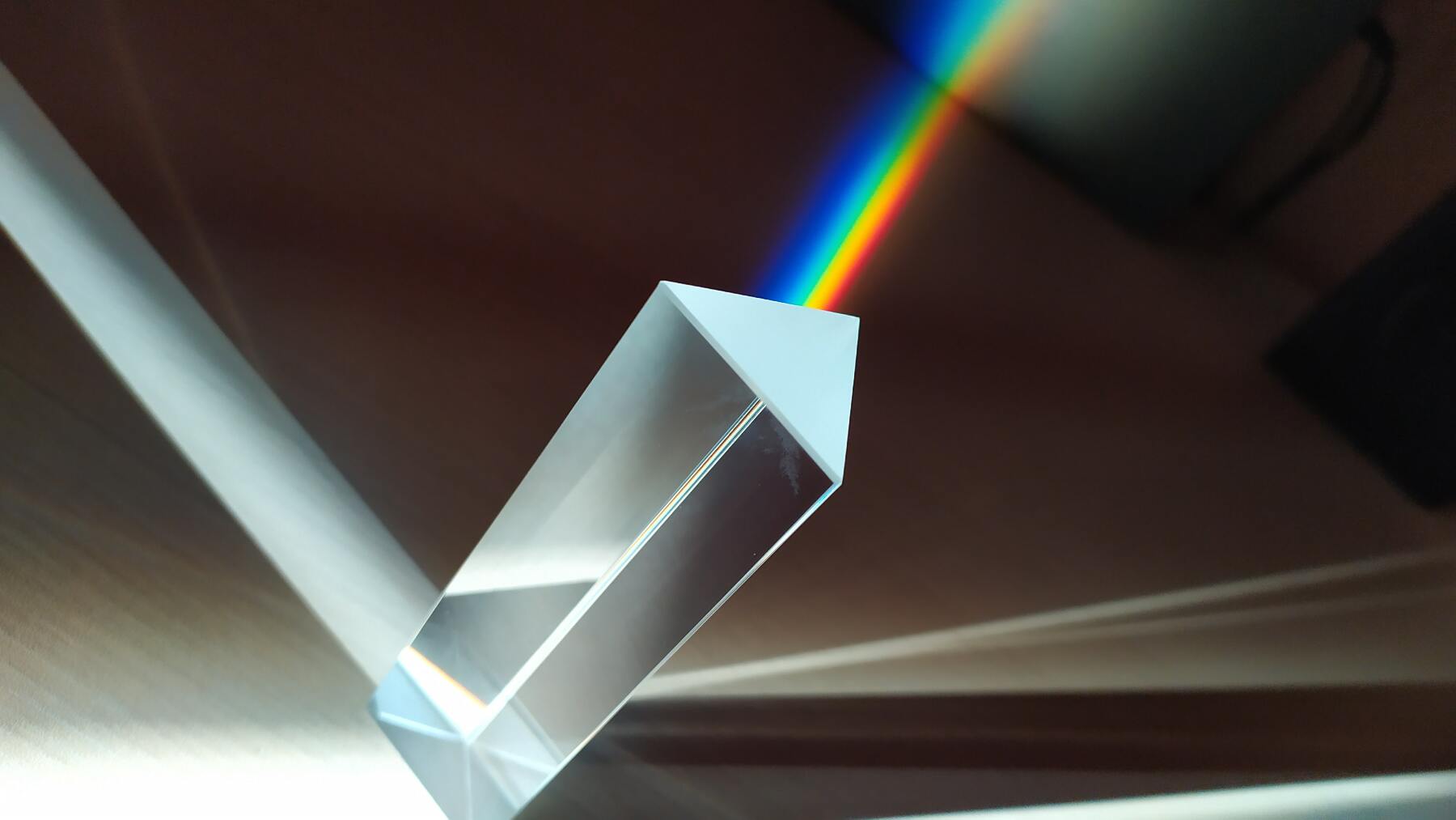 White light being split into colors by a prism. The white light shines on the prism from the bottom left, and a big part of it is refracted and split as it passes through the prism. image credit Pexels
